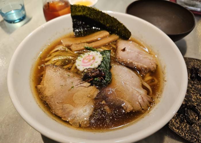 ANTCICADA's famous cricket ramen, featuring a soy sauce-based broth with chashu pork, naruto fishcake, seaweed and a crispy cricket.