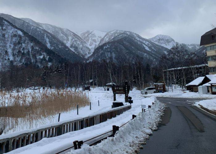 A road in Nikko, as seen in winter with snow-capped mountains in the background.