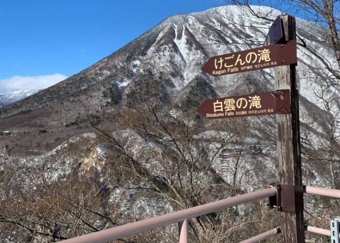 A signpost that points to two of Nikko's famous waterfalls during winter.