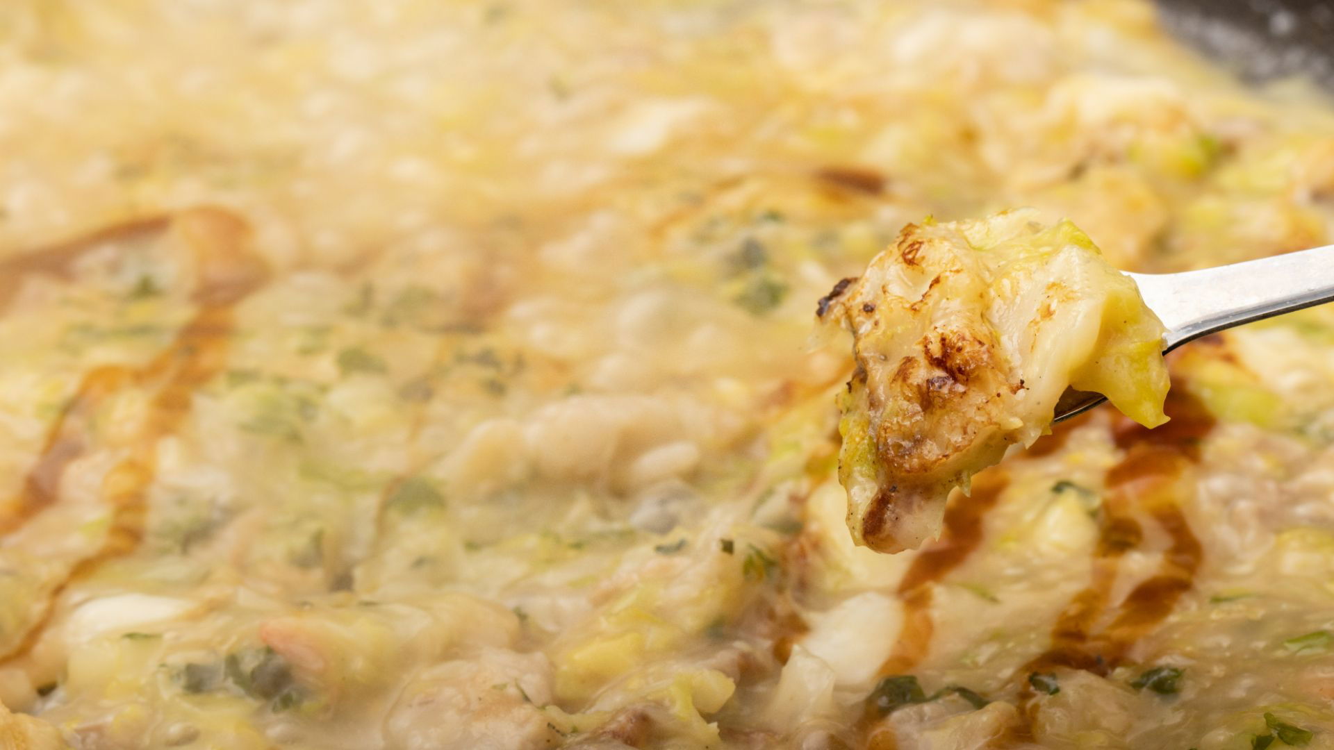 Close-up of sizzling Okonomiyaki on a hot plate