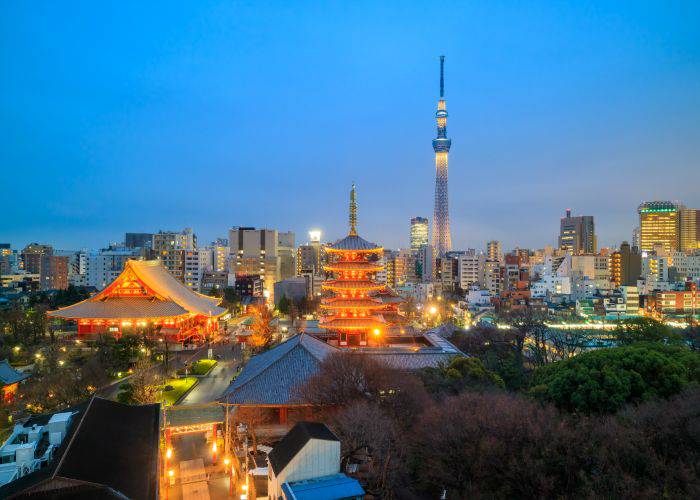 The sun begins to set over Asakusa, lit up against the skyline of Tokyo.