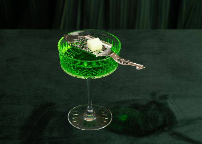 The bright green visage of an absinthe cocktail, such as might be served at Record Bar Analog.