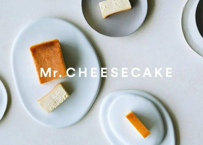 The logo of Mr. Cheesecake over an image of cheesecake on plates.