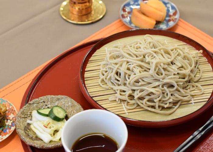 Fresh chilled soba noodles on a bamboo mat with Japanese pickles and dipping sauce