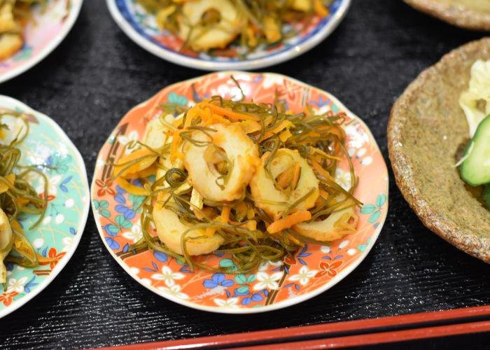 Japanese side dishes such as chilled pickles on colorful orange and blue plates