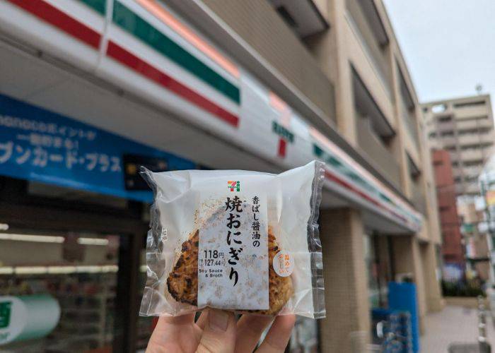 Kevin holding a yaki onigiri outside of a 7-11 in Japan.