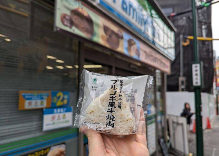 Kevin holding a bulgogi beef onigiri outside of a Family Mart.