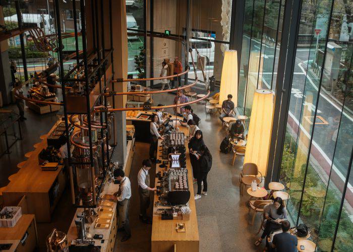 The warm woods and sleek glass interiors of the Starbucks Roastery Tokyo.