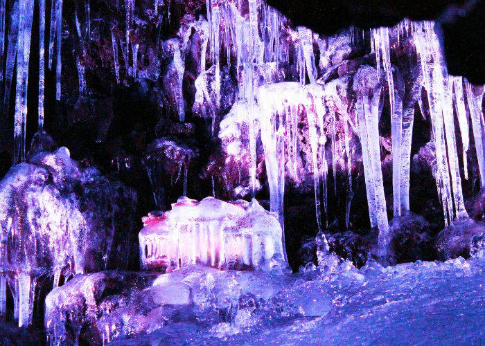 The awe-inspiring icicles of Narusawa Ice Cave, lit up by a purple spotlight.