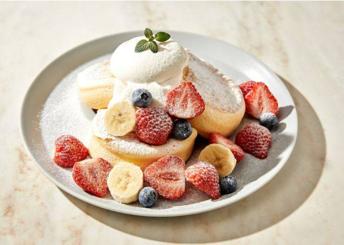 Fluffy pancakes at Flipper’s Shibuya, covered in fresh fruit and ice cream.