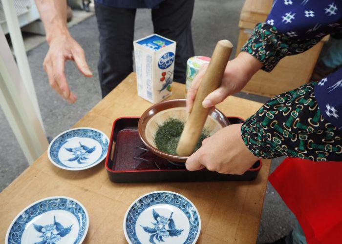 A person mixing and creating tea leaf sea salt using a pestle and mortar
