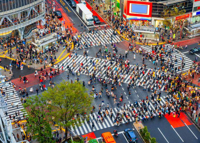 The famous Shibuya Scramble Crossing as seen from above; countless people are crossing this iconic intersection.