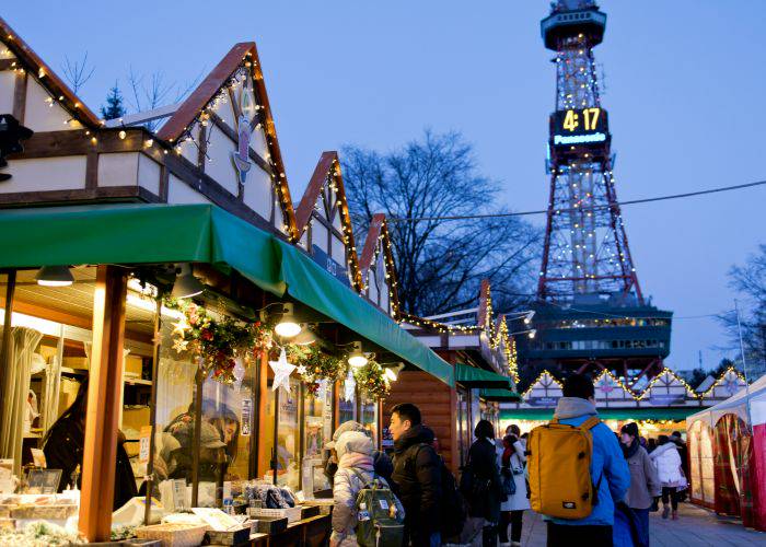 A Japanese Christmas Market, with people stopping at fairy-lit stalls.