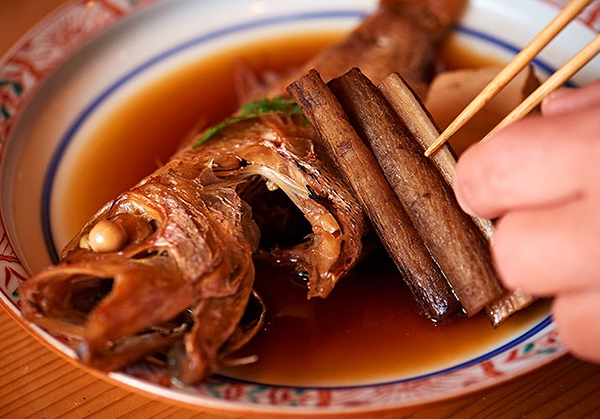 Gourmet fish dish with chopsticks in traditional restaurant setting