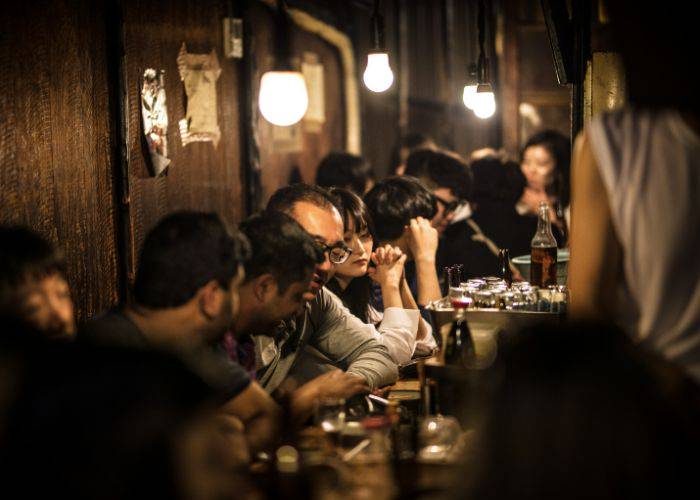 A crowded izakaya in Shinjuku, filled with late-night diners.