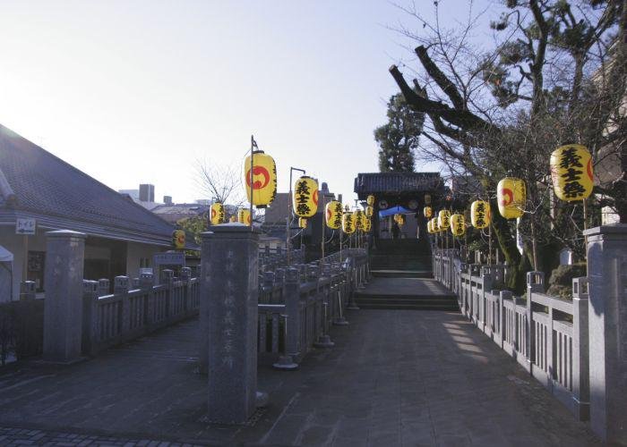 The burial place for the 47 ronin's with yellow hanging lanterns in the trees