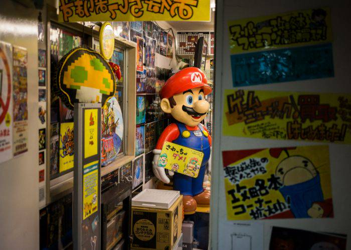 Peeking through the door of a Super Potato, where a Mario statue can be seen.