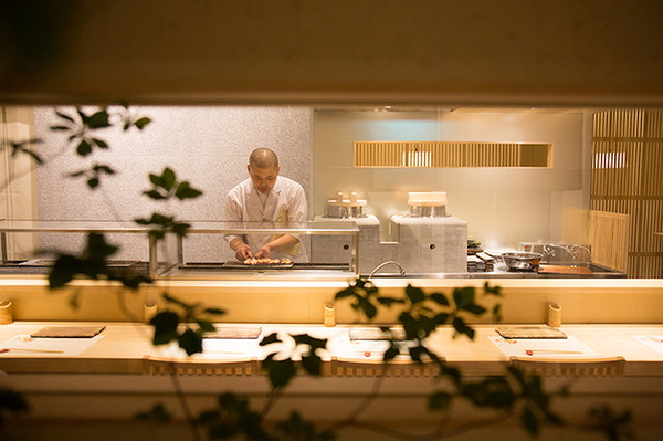 Chef preparing dishes at a modern Japanese restaurant kitchen