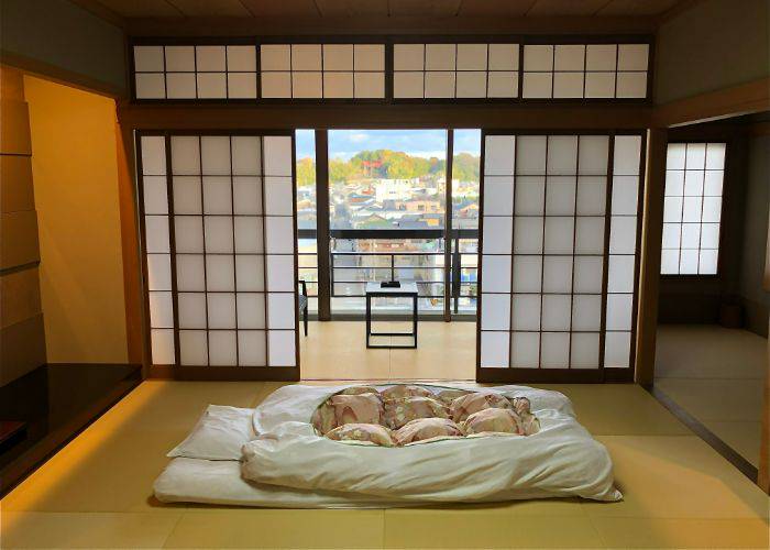 A traditional ryokan room with tatami floor and scenic views.