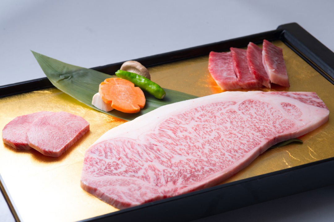 Luxury wagyu beef and vegetables on a golden platter
