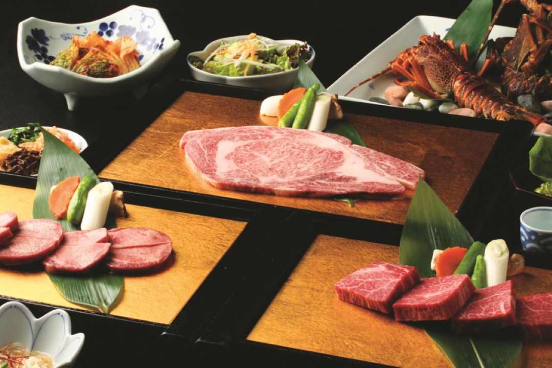 Gourmet Japanese beef course with assorted vegetables and seafood