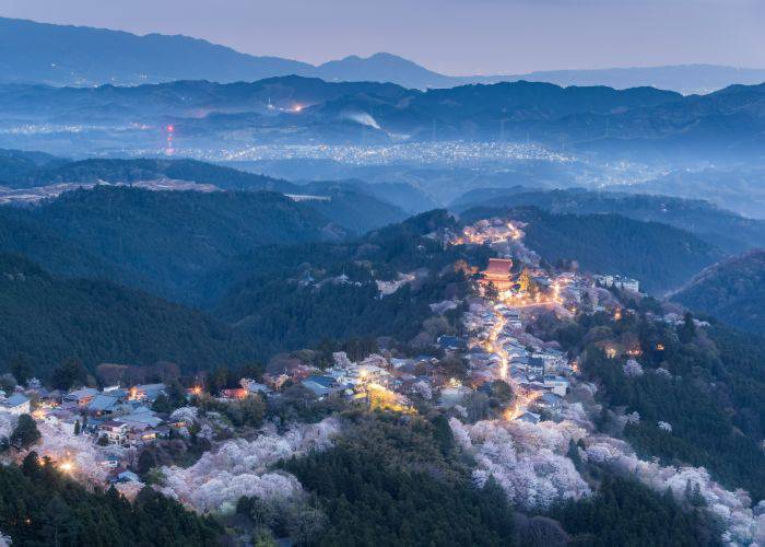 An aerial shot of Yoshino, Nara, lit up as the sun sets.