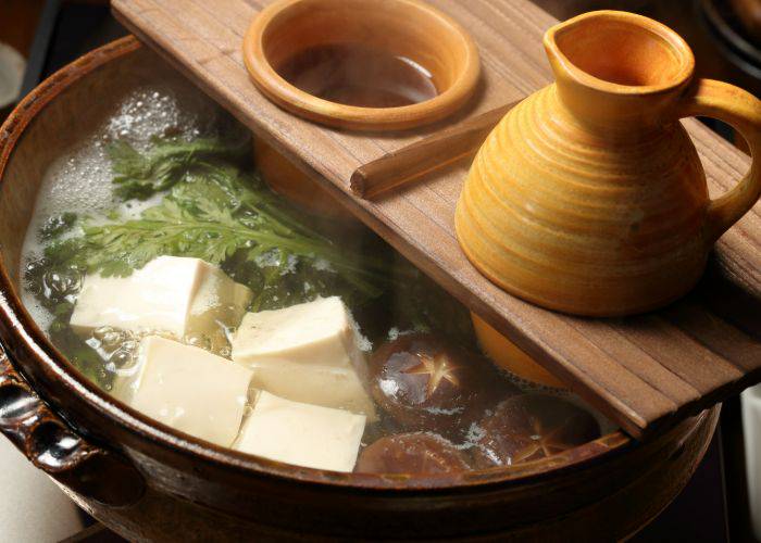 A fancy serving of yudofu, featuring blocks of tofu in a boiling broth.