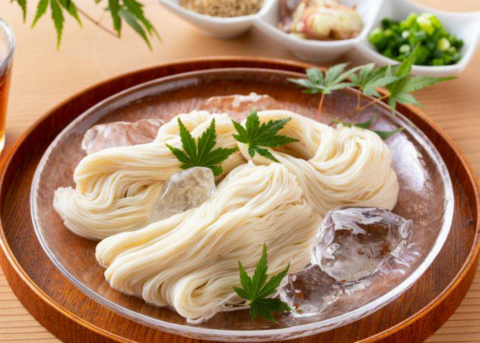 Bundles of chilled somen noodles resting in ice.