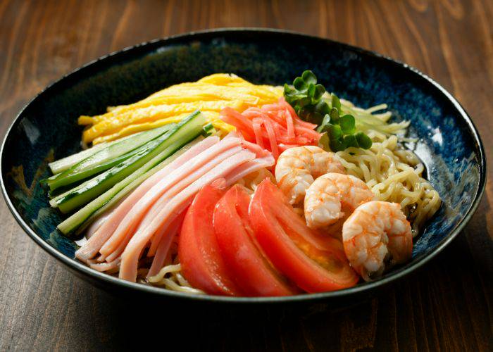 A fresh bowl of hiyashi chuka, featuring fresh vegetables, meats and cold noodles.