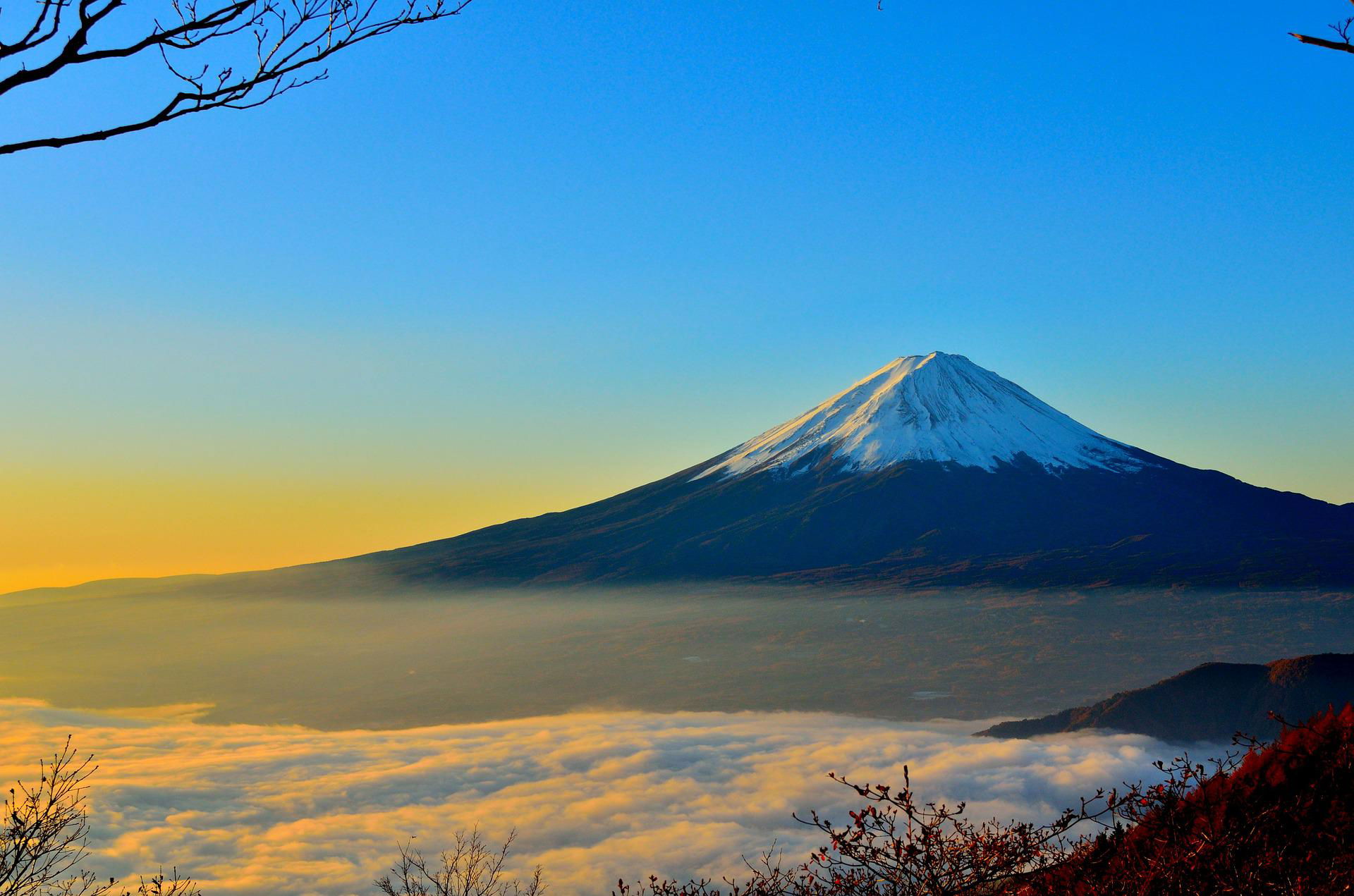 The snow-topped peak of Mt. Fuji, towering above the clouds.