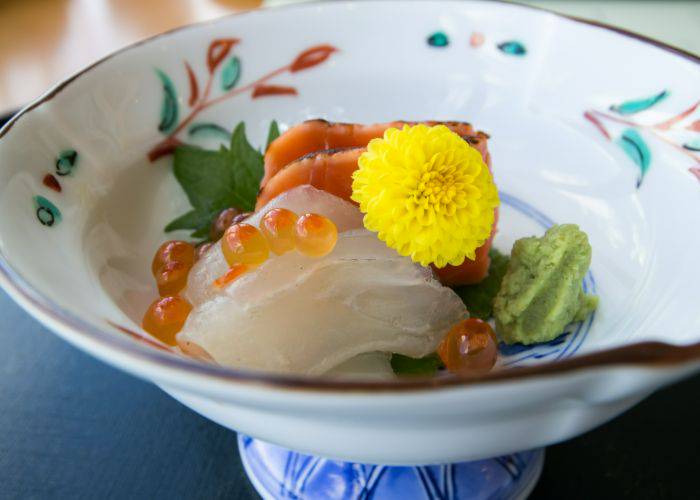 A luxurious serving of seafood, including salmon and roe.