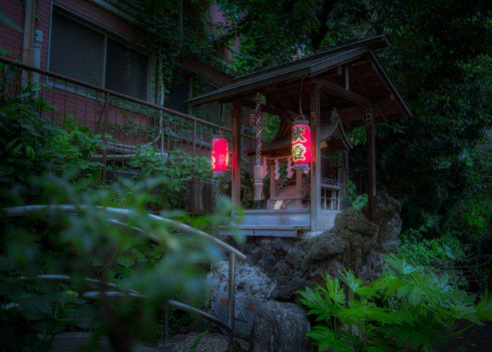 Tsunokami Benzaiten Shrine at night, glowing with lanterns.