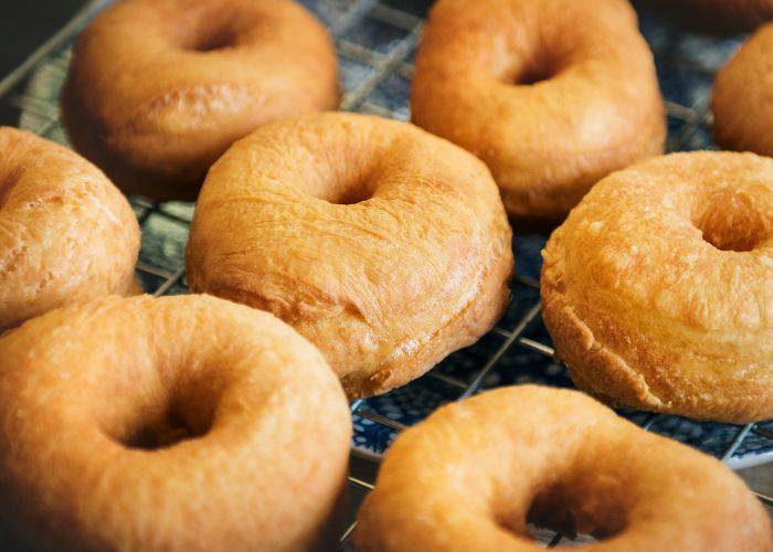 Plain donuts sitting on a drying rack