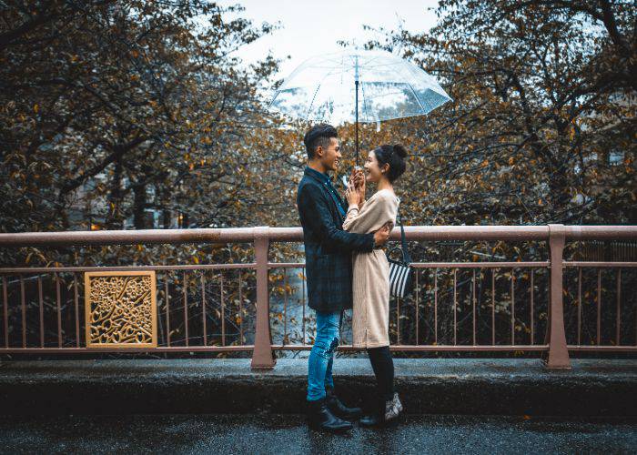 A couple holding each other under an umbrella in Japan.