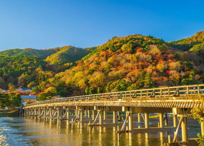 The iconic Togetsukyo Bridge in Arashiyama during fall.