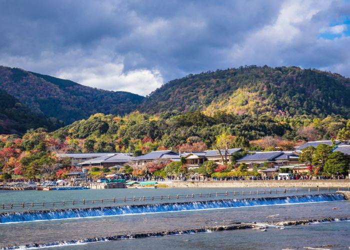 Kyoto's Katsura River set against a backdrop of mountain forests.