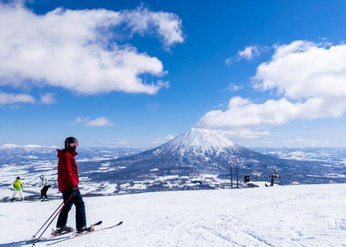 A ski-er on the slopes of Niseki; in the background, a snow-topped mountain.