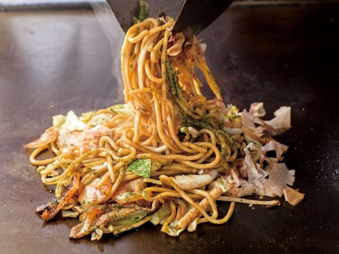 Delicious yakisoba noodles being cooked with fresh vegetables.