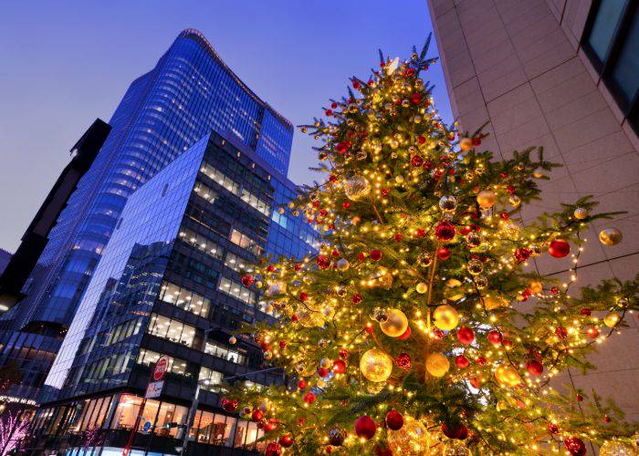 An illuminated Christmas tree set against Tokyo's high-rise buildings.