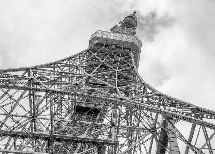 A black-and-white shot of Tokyo Tower stretching into a cloudy sky.