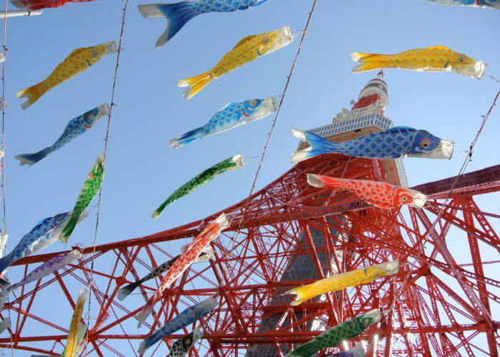 Carp streamers decorating the base of Tokyo Tower on a clear day.