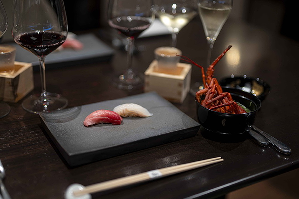 Elegant sushi presentation with wine and lobster
