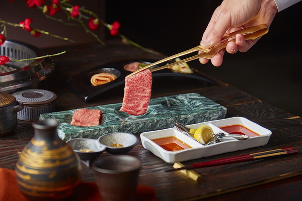 Premium beef slice at elegant Japanese restaurant with flavorful sauces.