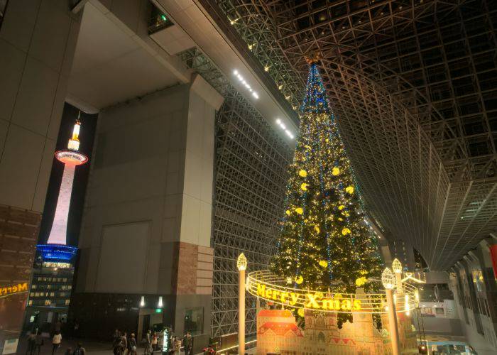 A gigantic Christmas tree in Kyoto Station, with Kyoto Tower in the background.