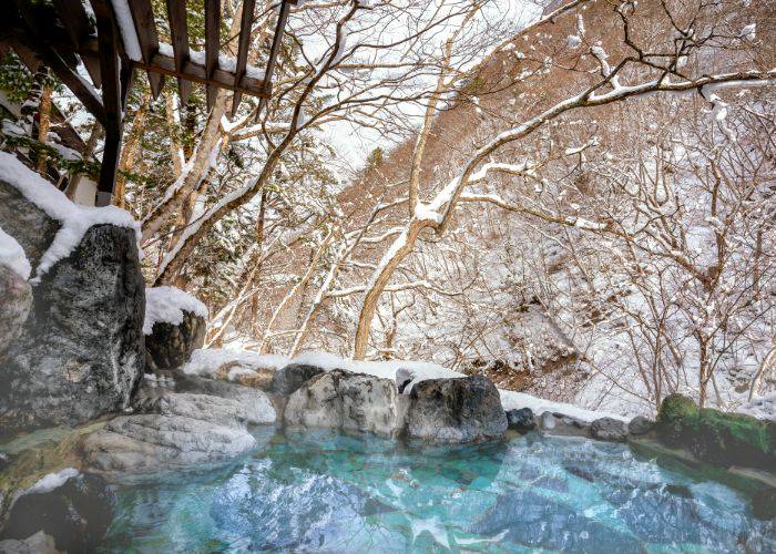 Snow-covered views from a hot spring during winter in Kyoto.