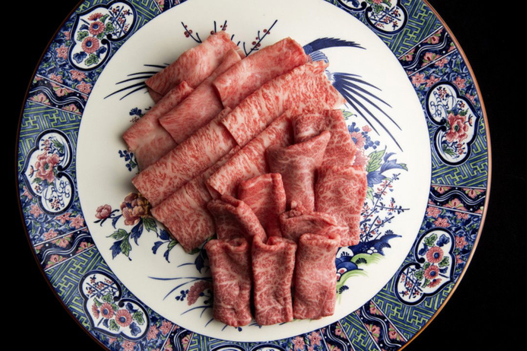Plated Japanese Wagyu beef slices on decorative porcelain