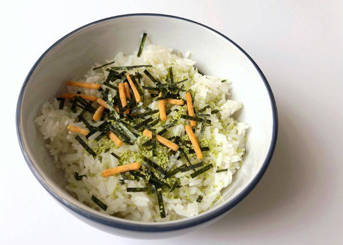 A bowl of ochazuke made from a packet of instant ochazuke. It is topped with nori and other vegetables