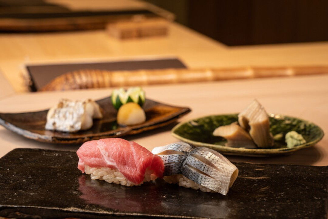 Elegant sushi course featuring tuna and mackerel nigiri on a stone plate