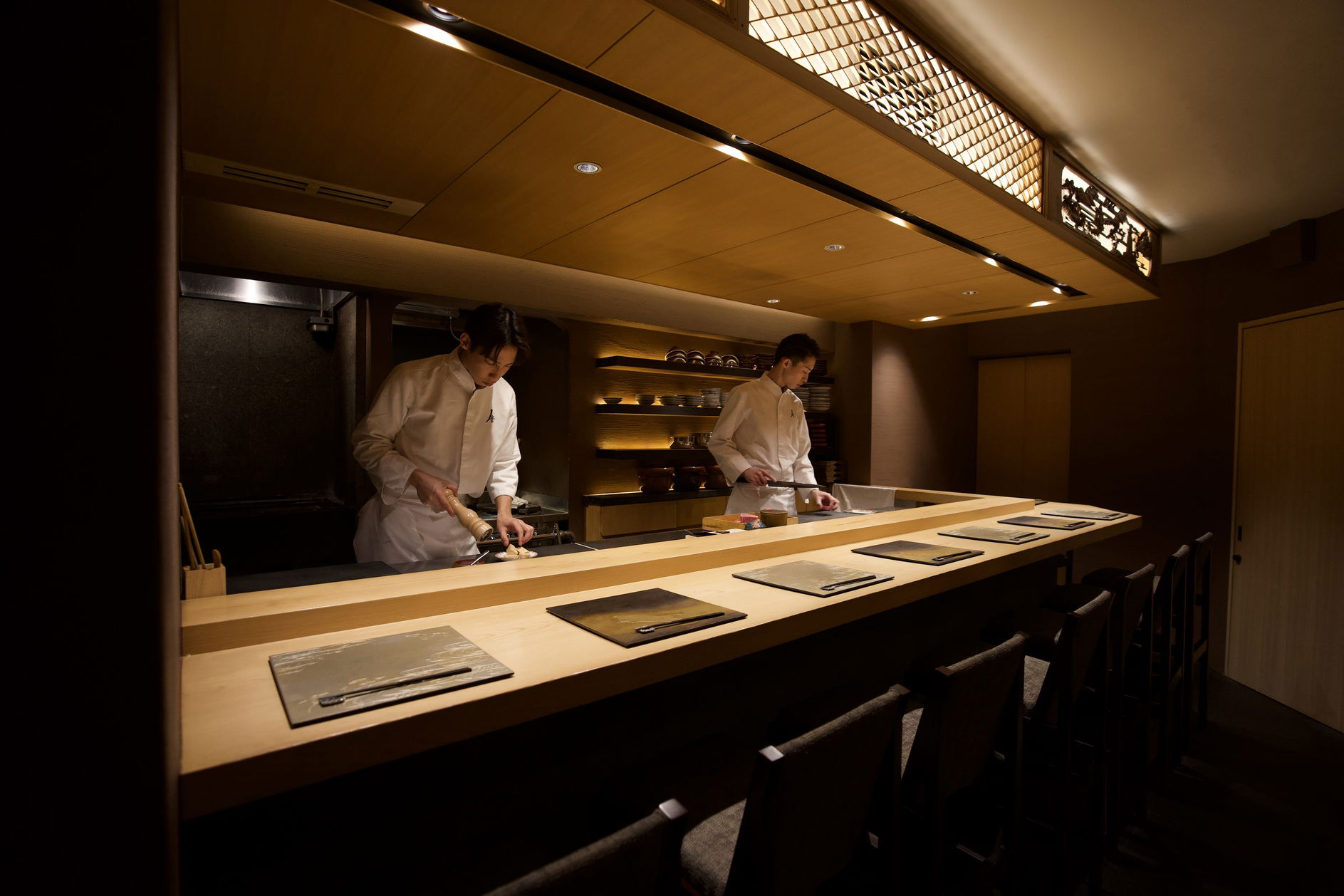 Chefs preparing dishes in an elegant Japanese restaurant kitchen
