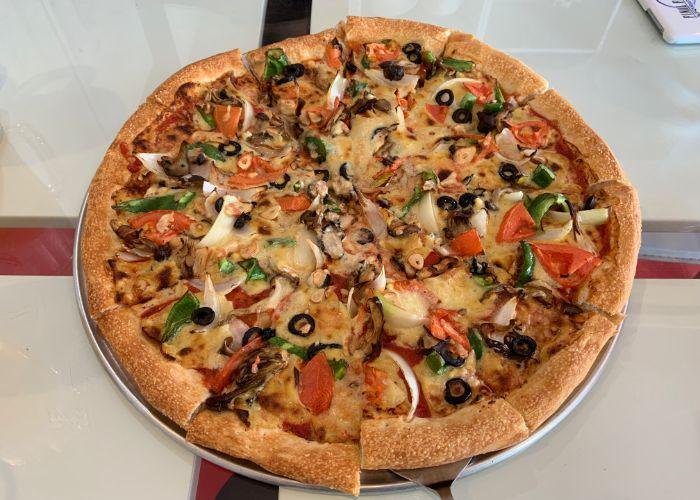 Colorful veggie vegan pizza with olives, garlic, mushrooms, and tomato, from Pizza Sun in Okinawa